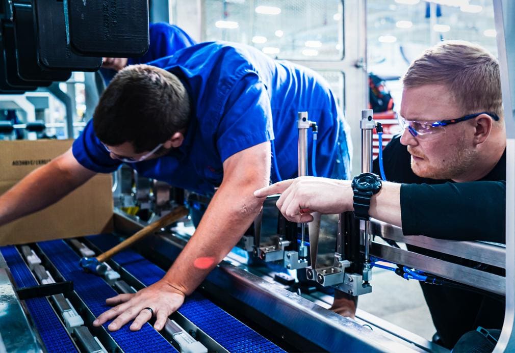 Packaging plant technicians in motion near production line equipment